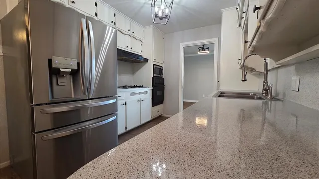 a kitchen with stainless steel appliances a refrigerator a stove a sink and a refrigerator