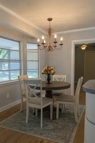 a dining room with furniture a chandelier and window