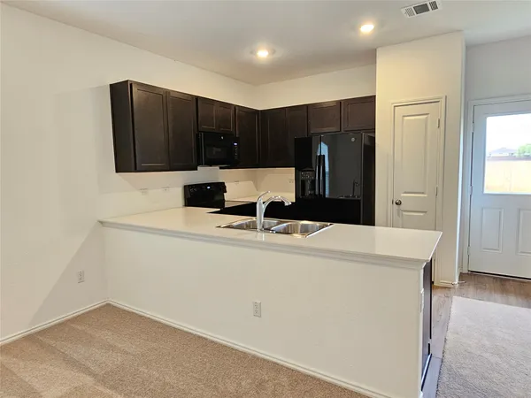 a kitchen with kitchen island cabinets and refrigerator