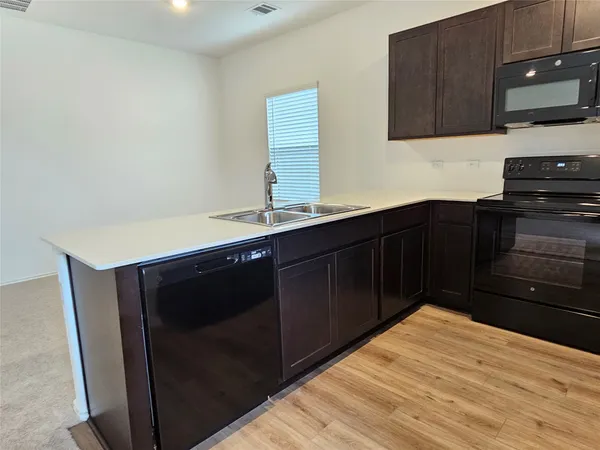 a kitchen with stainless steel appliances wooden cabinets and a sink