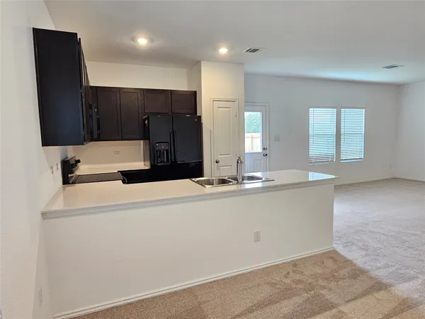 a large white kitchen with a sink and dishwasher