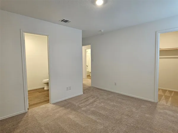 an empty room with closet and windows