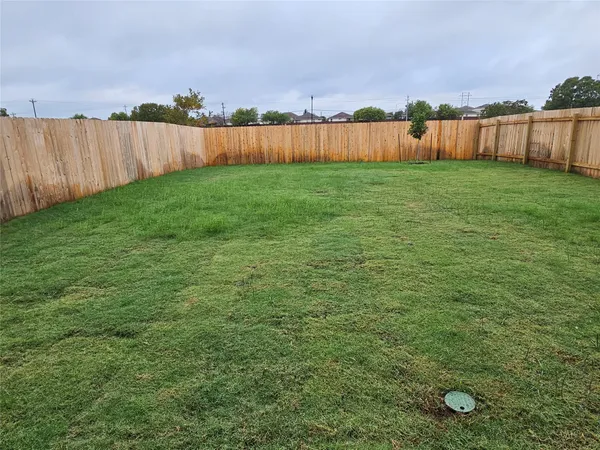 a view of yard with wooden fence