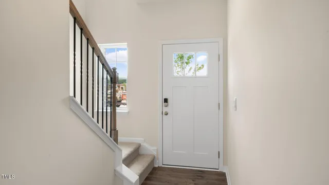 an entryway with a white walls and stairs