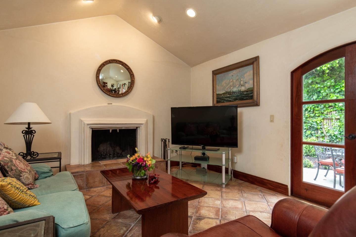 1007 Ocean Road Pebble Beach, CA 93953 - Photo 16 of 24 a living room with furniture a flat screen tv and a fireplace