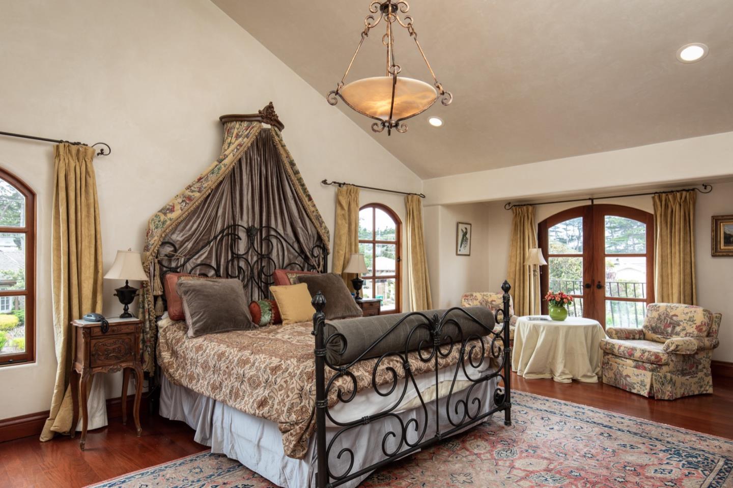1007 Ocean Road Pebble Beach, CA 93953 - Photo 19 of 24 a bedroom with a bed and a chandelier