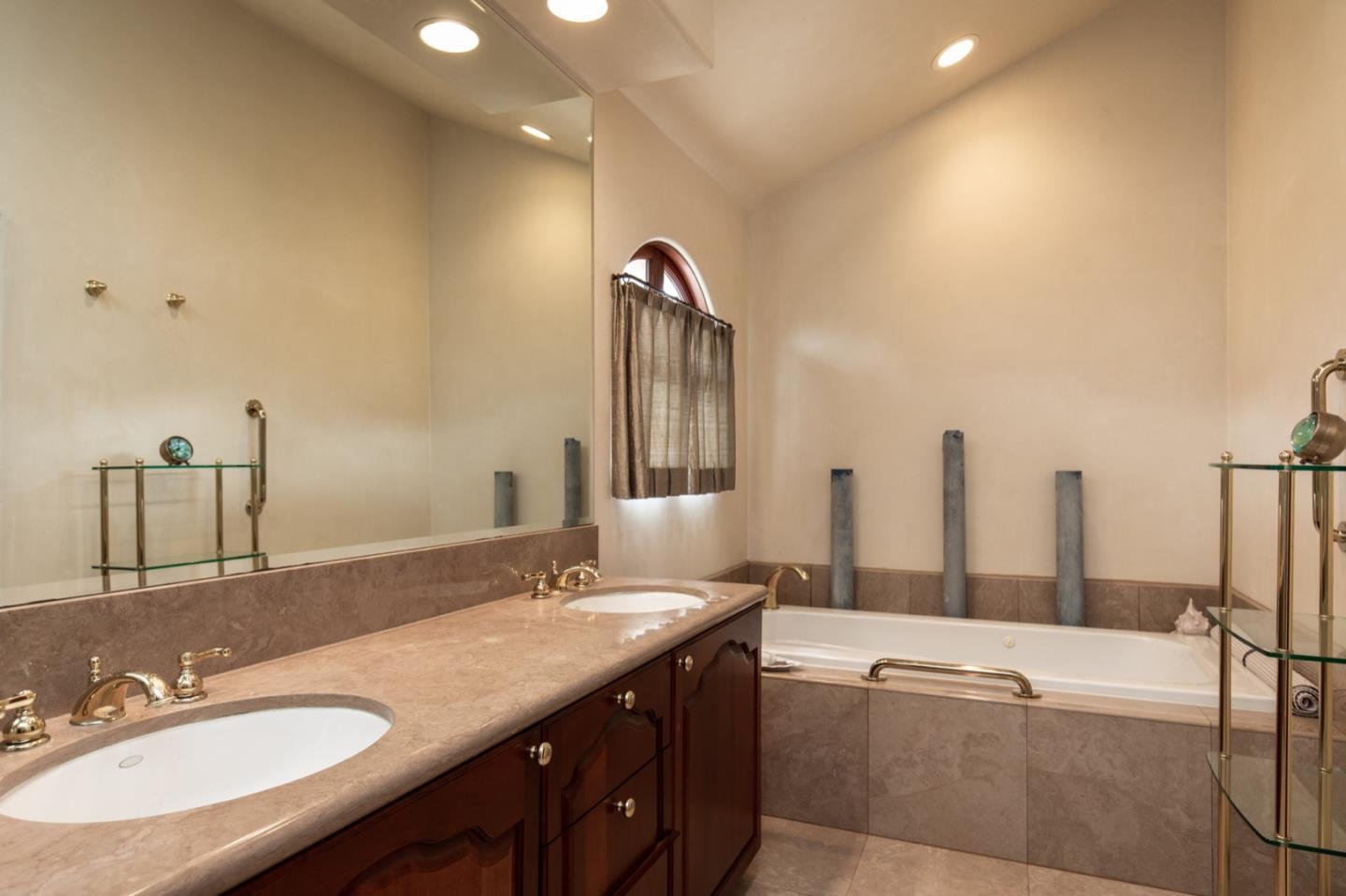 1007 Ocean Road Pebble Beach, CA 93953 - Photo 21 of 24 a spacious bathroom with a granite countertop sink and a mirror