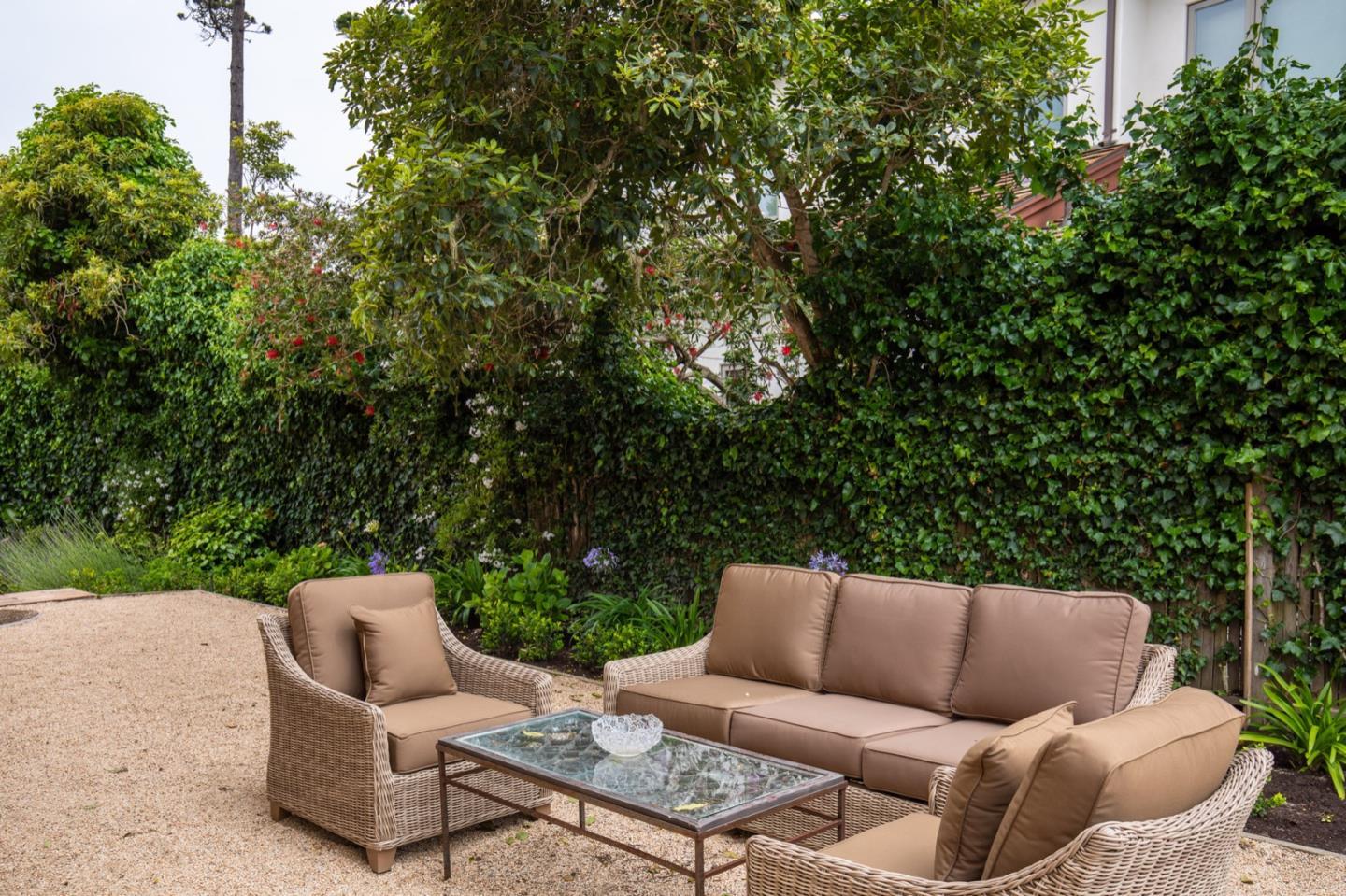 1007 Ocean Road Pebble Beach, CA 93953 - Photo 7 of 24 a backyard of a house with table and chairs
