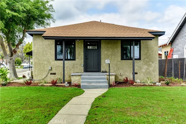 a front view of a house with a garden