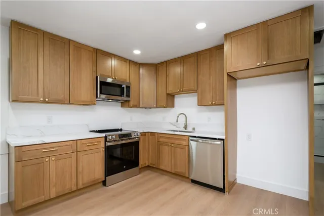 a kitchen with stainless steel appliances granite countertop a sink stove and refrigerator
