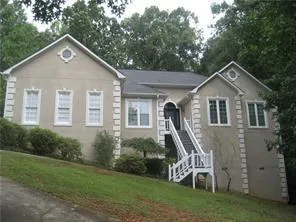 a front view of a house with a yard and trees