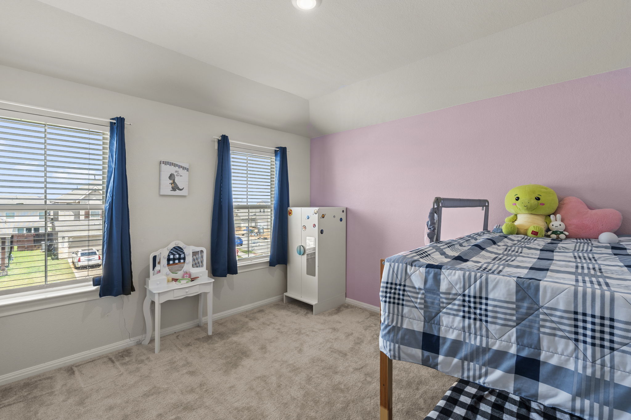 548 Purple Heart Drive Buda, TX 78610 - Photo 21 of 35 A cozy bedroom with soft carpeting and ample natural light through well-appointed windows.