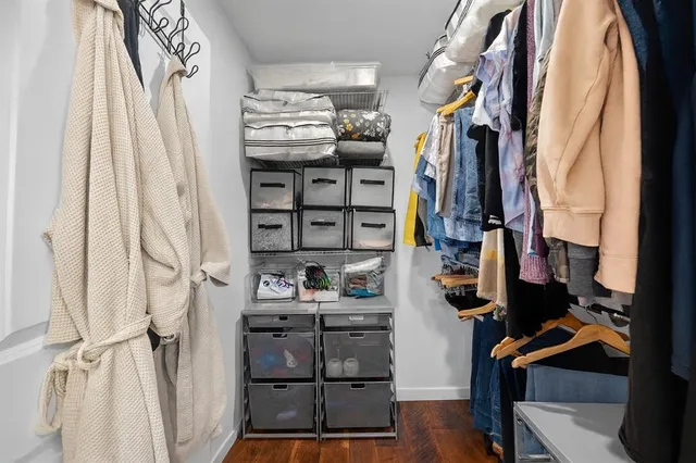 a view of walk in closet with clothes and shoes