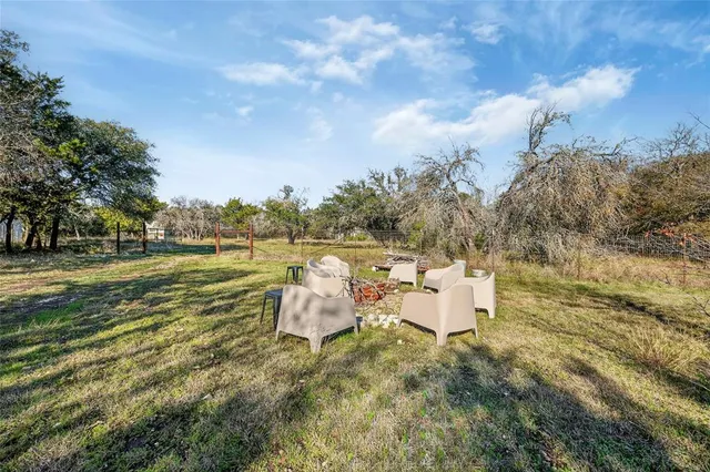 a backyard of a house with table and chairs