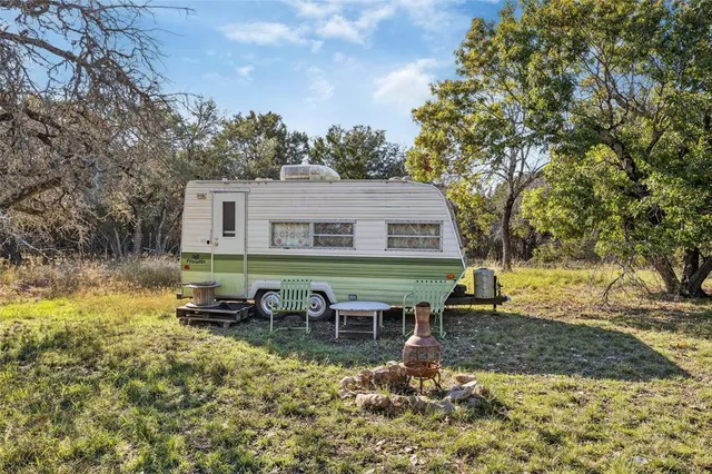 a backyard of a house with table and chairs