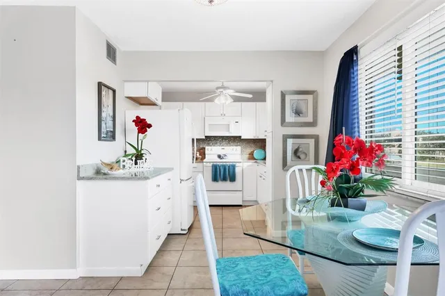 a kitchen with furniture a chandelier and wooden floor