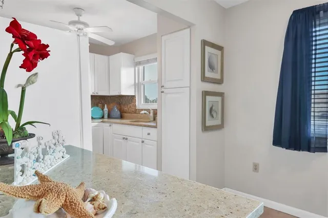 a kitchen with stainless steel appliances granite countertop a refrigerator sink and white cabinets