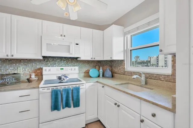 a kitchen with stainless steel appliances granite countertop white cabinets a sink and dishwasher with wooden floor