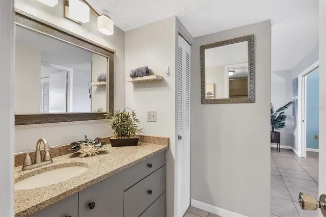 a bathroom with a granite countertop sink vanity and mirror