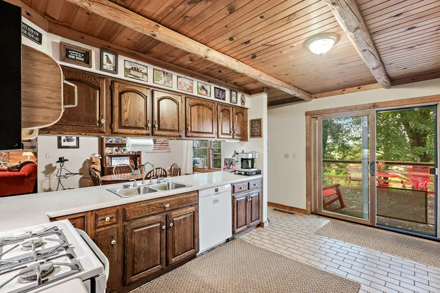 a utility room with stainless steel appliances granite countertop a sink and cabinets