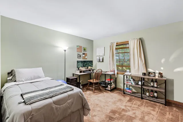 a bedroom with furniture and a large window