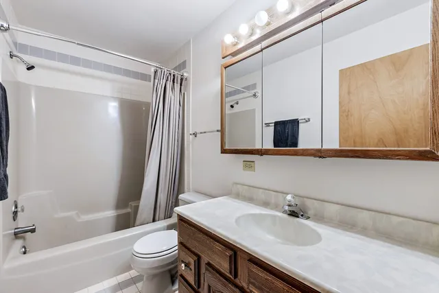a bathroom with a granite countertop sink toilet mirror and shower