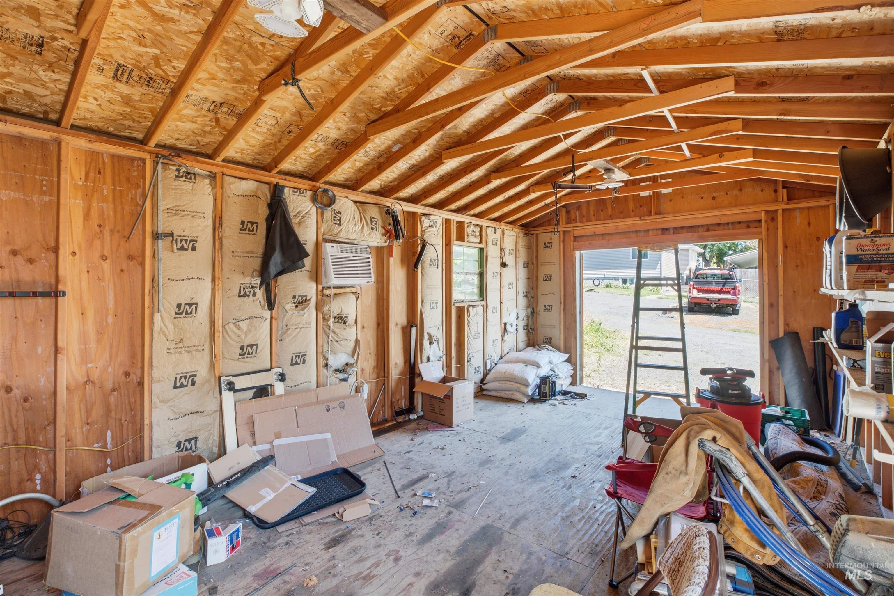 735 Oak Street Potlatch, ID 83855 - Photo 18 of 30 Wood-frame garage structure featuring an exposed rafter ceiling, partial wall insulation, and a roll-up garage door opening