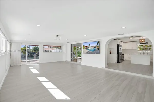 a view of a hallway with wooden floor and a living room