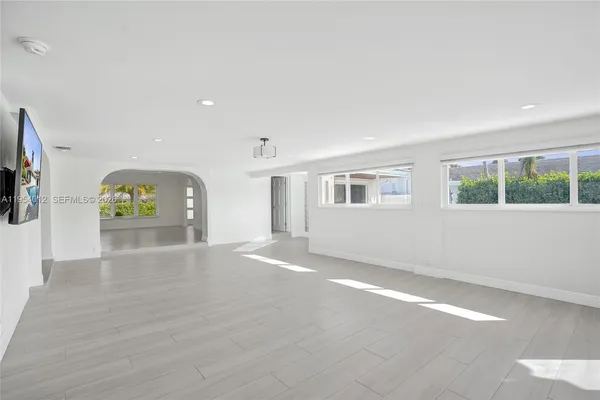 an empty room with windows and fireplace
