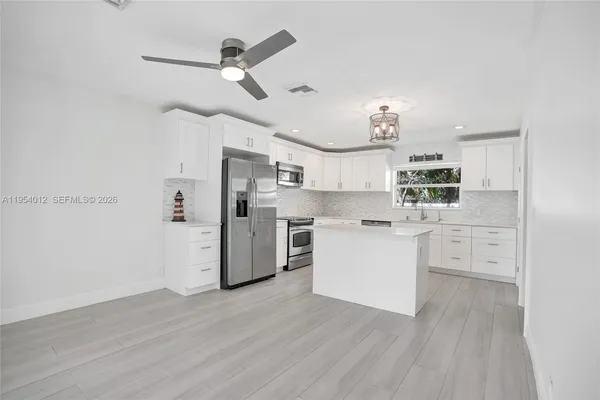 a kitchen with white cabinets and stainless steel appliances