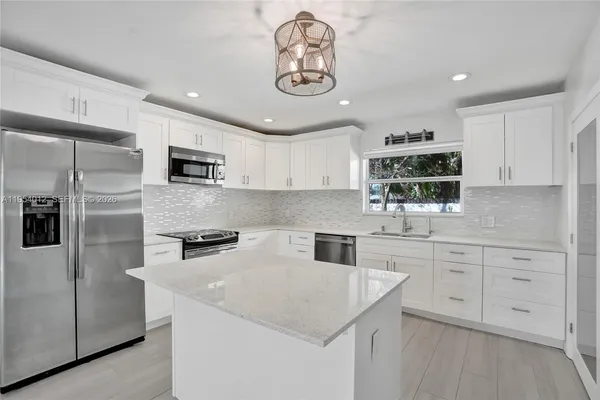 a kitchen with appliances a sink and cabinets