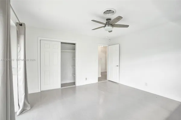 an empty room with closet and windows