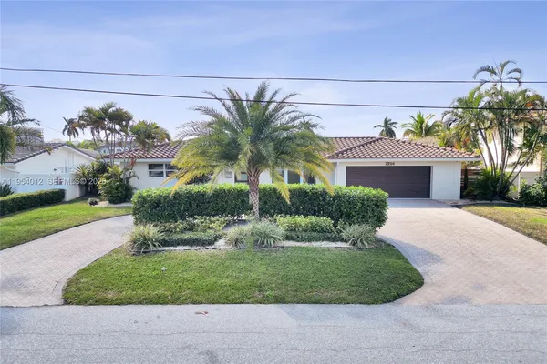 a front view of a house with a garden and a yard