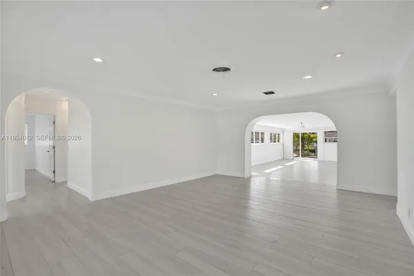 a view of empty room with wooden floor