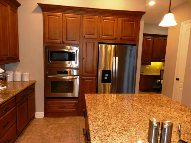a kitchen with stainless steel appliances granite countertop a refrigerator and a sink