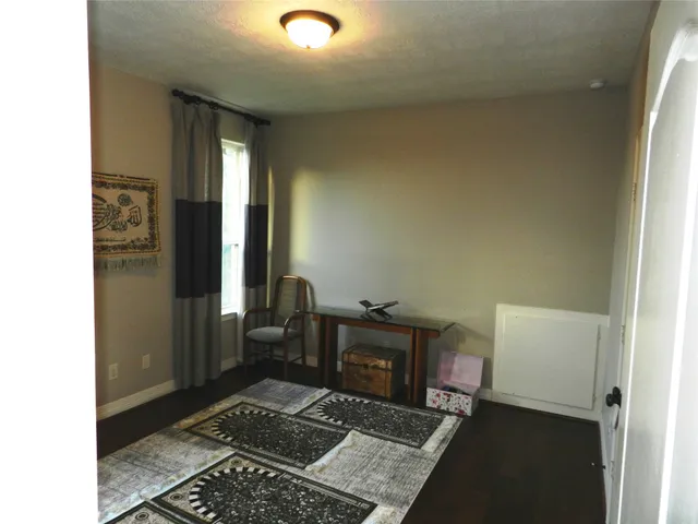 a view of a hallway with wooden floor and a living room