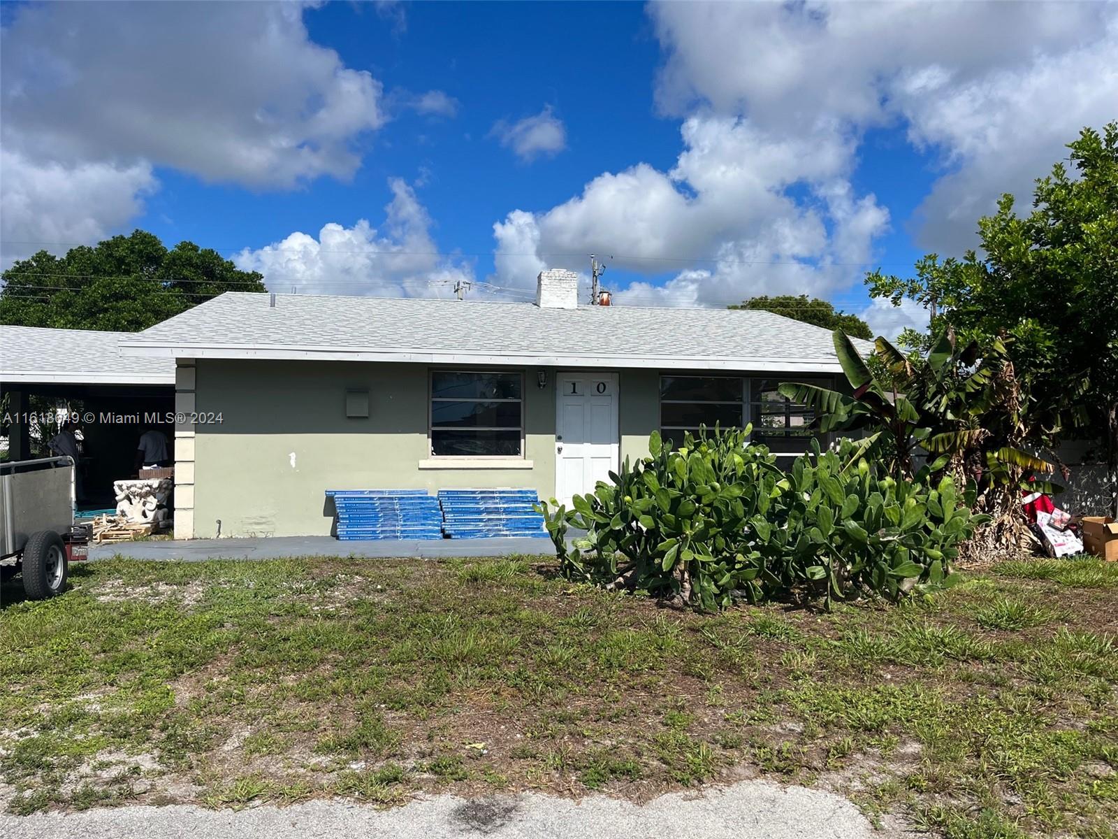977 Miner Road, Unit 10 Lake Worth, FL 33462 - Photo 1 of 1 a front view of a house with garden