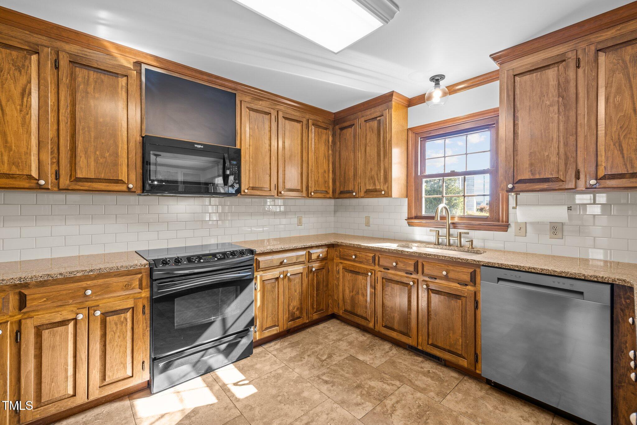 7205 Penny Road Raleigh, NC 27606 - Photo 11 of 50 a kitchen with stainless steel appliances granite countertop wooden cabinets a sink and dishwasher a stove with wooden floor