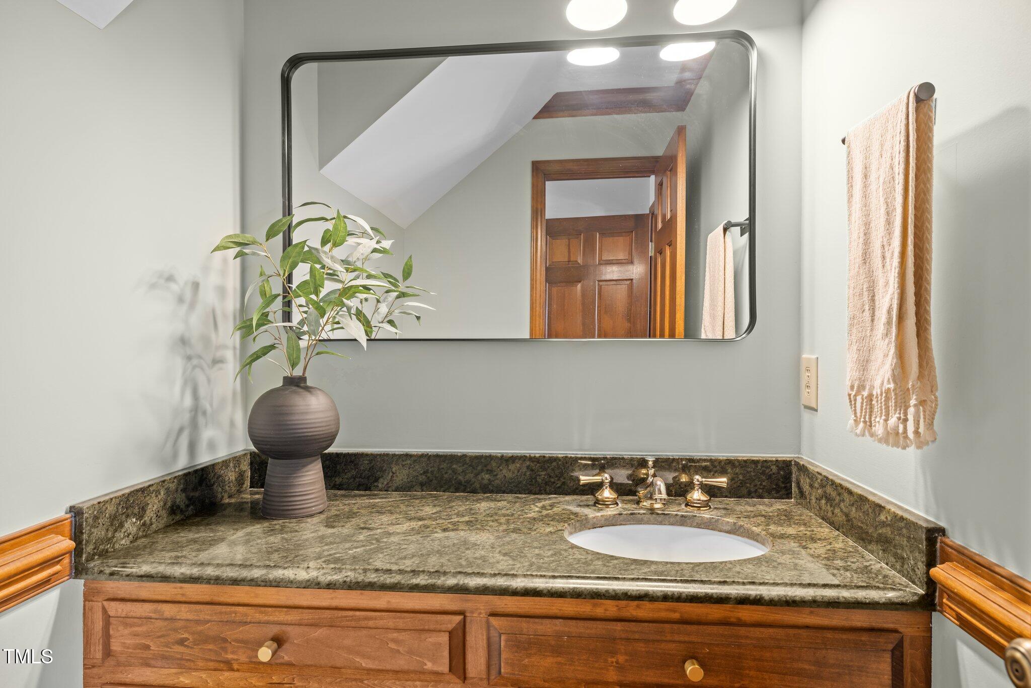 7205 Penny Road Raleigh, NC 27606 - Photo 15 of 50 a bathroom with a granite countertop sink and a mirror