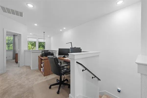 a view of a workspace with furniture and a window
