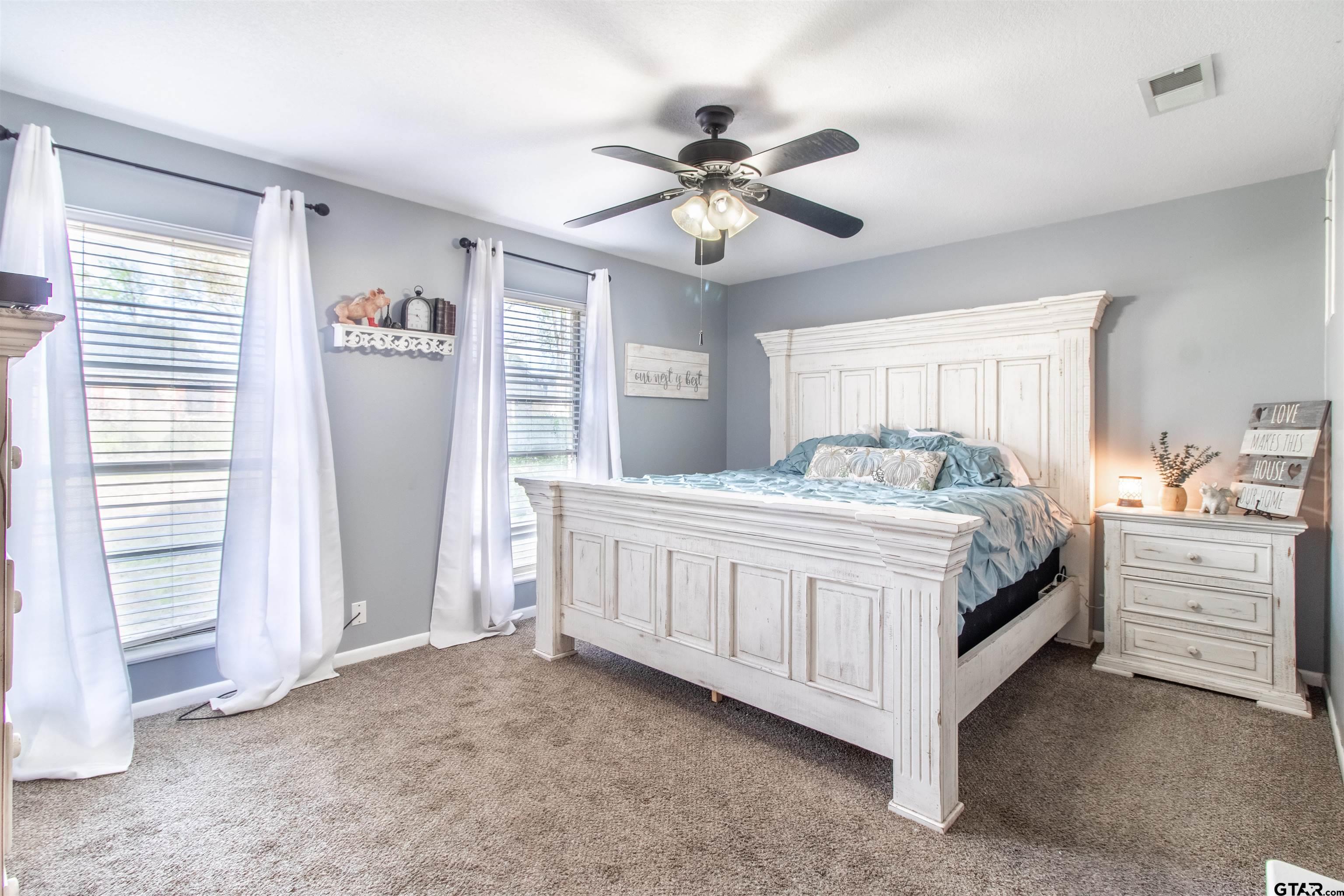 727 Oxford Drive Tyler, TX 75703 - Photo 14 of 33 a bedroom with a large bed and a chandelier
