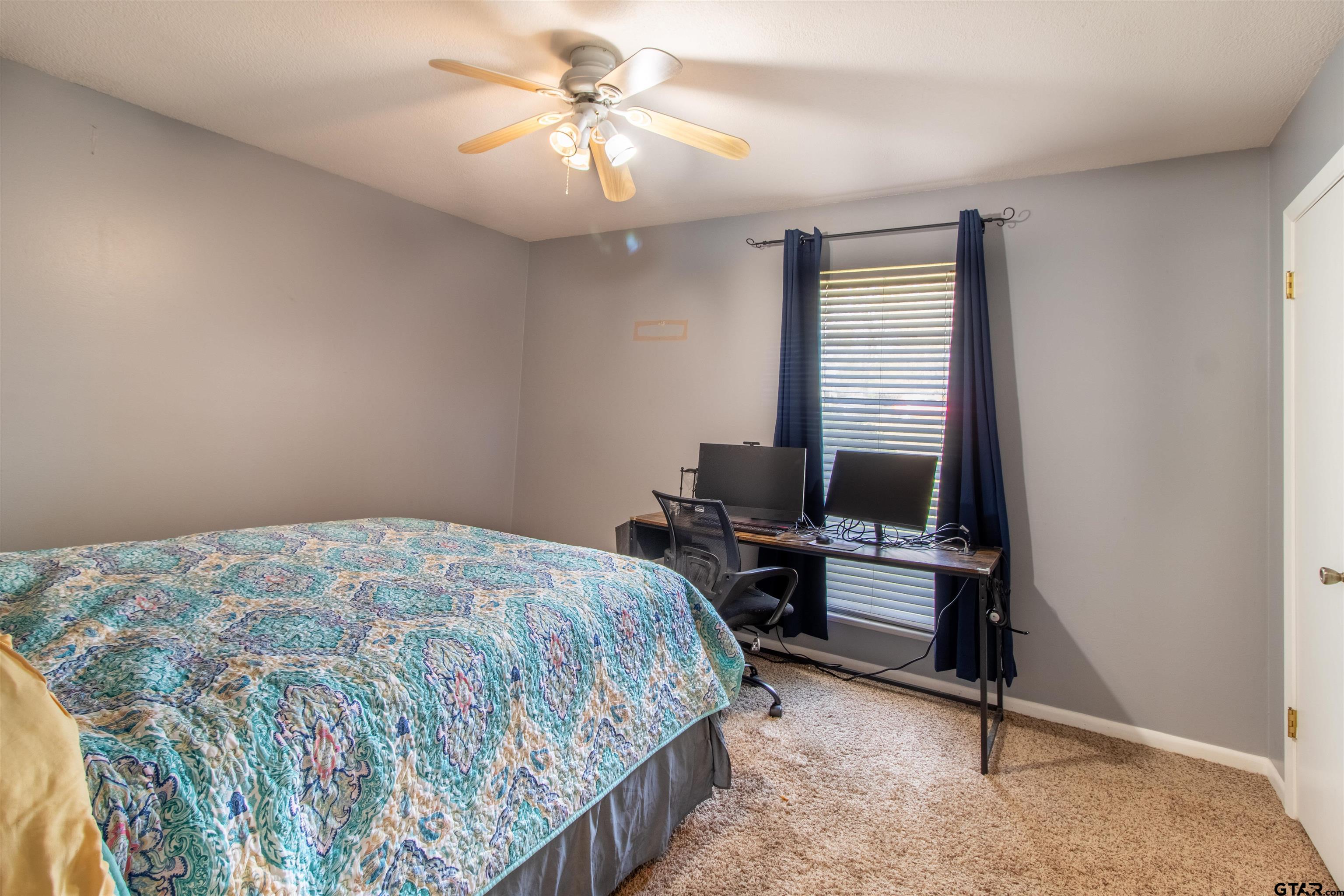 727 Oxford Drive Tyler, TX 75703 - Photo 17 of 33 a bedroom with a bed and a chandelier