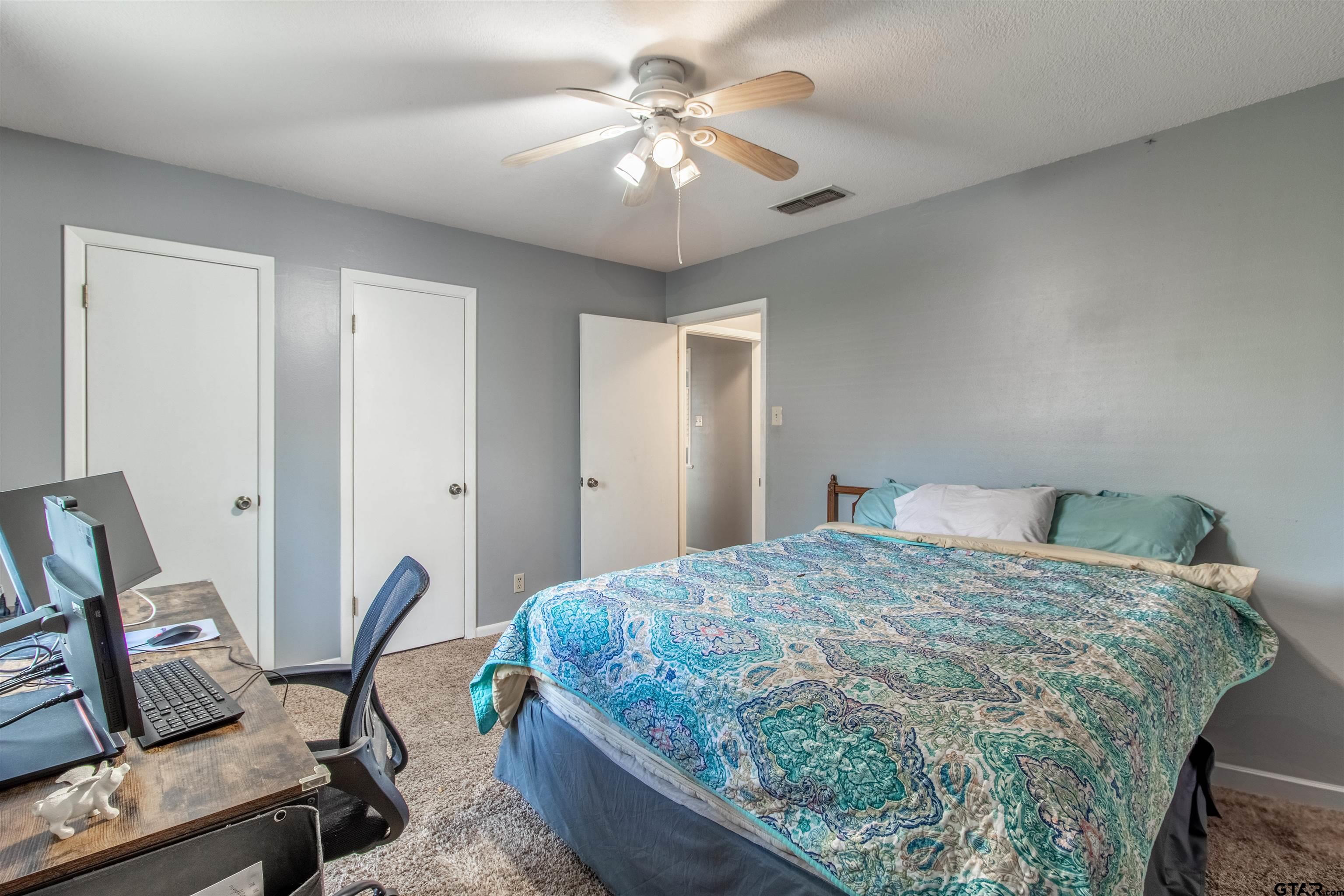 727 Oxford Drive Tyler, TX 75703 - Photo 18 of 33 a bedroom with a bed and a chandelier