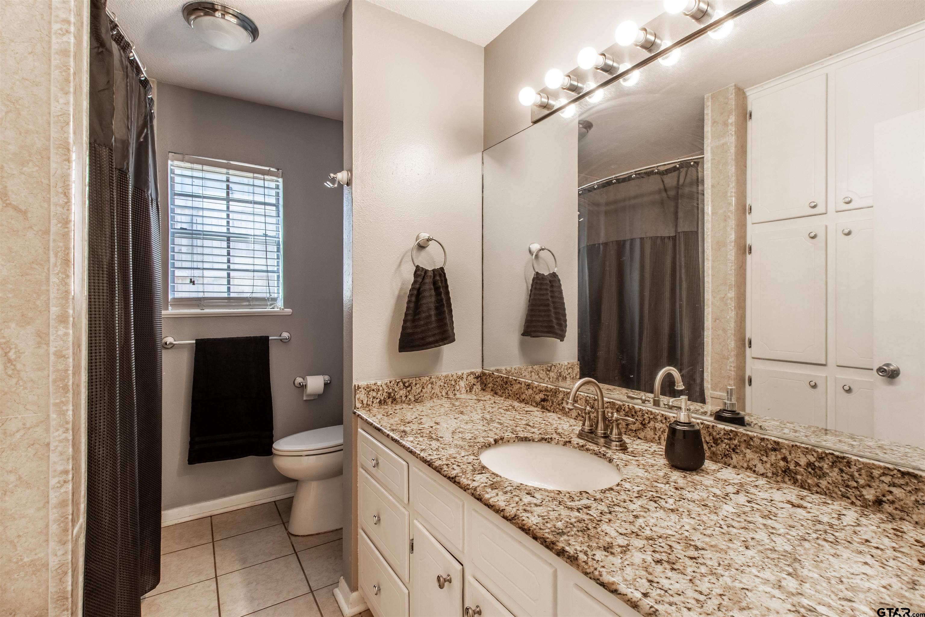 727 Oxford Drive Tyler, TX 75703 - Photo 19 of 33 a bathroom with a granite countertop sink and a mirror