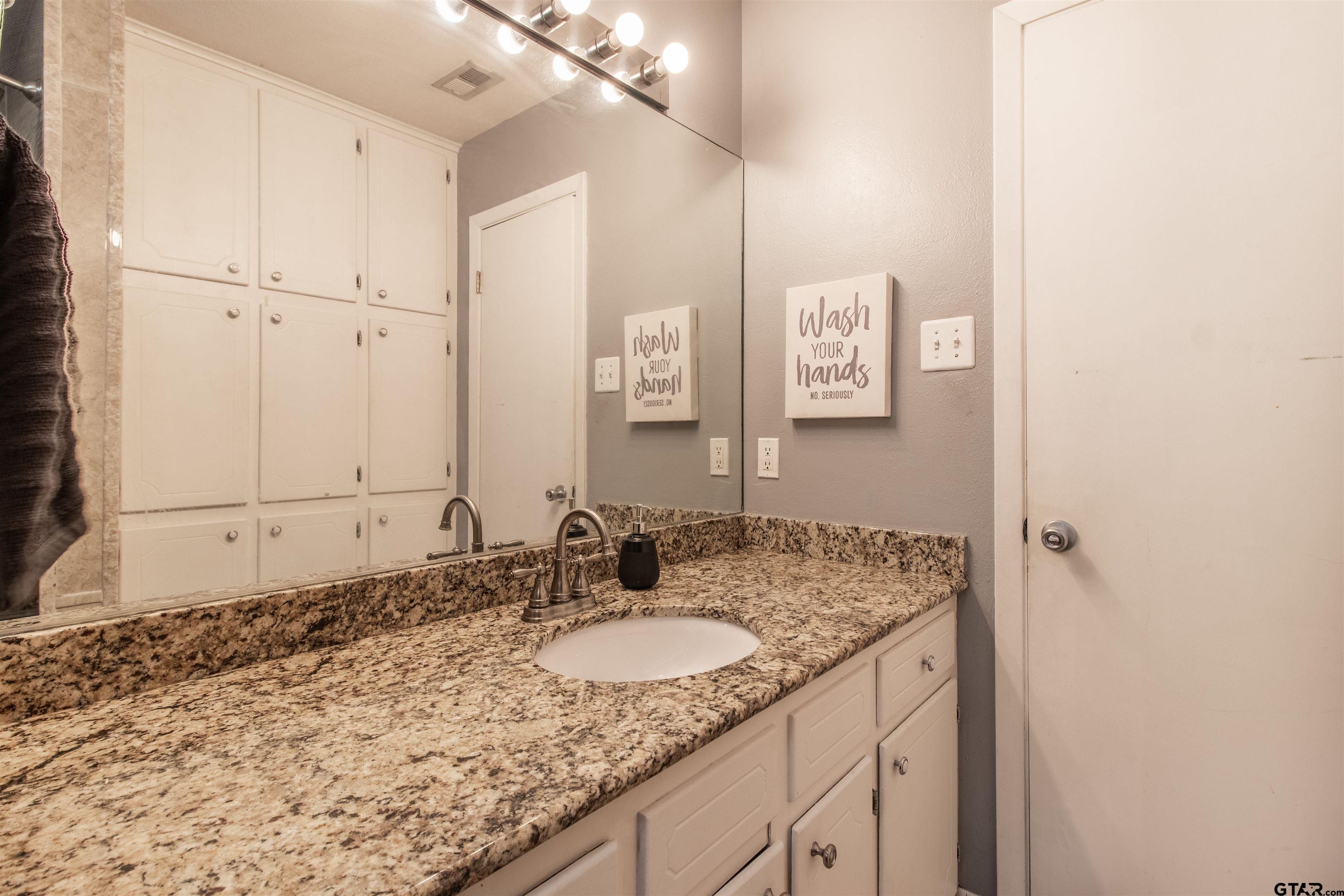 727 Oxford Drive Tyler, TX 75703 - Photo 20 of 33 a bathroom with a granite countertop sink and a mirror