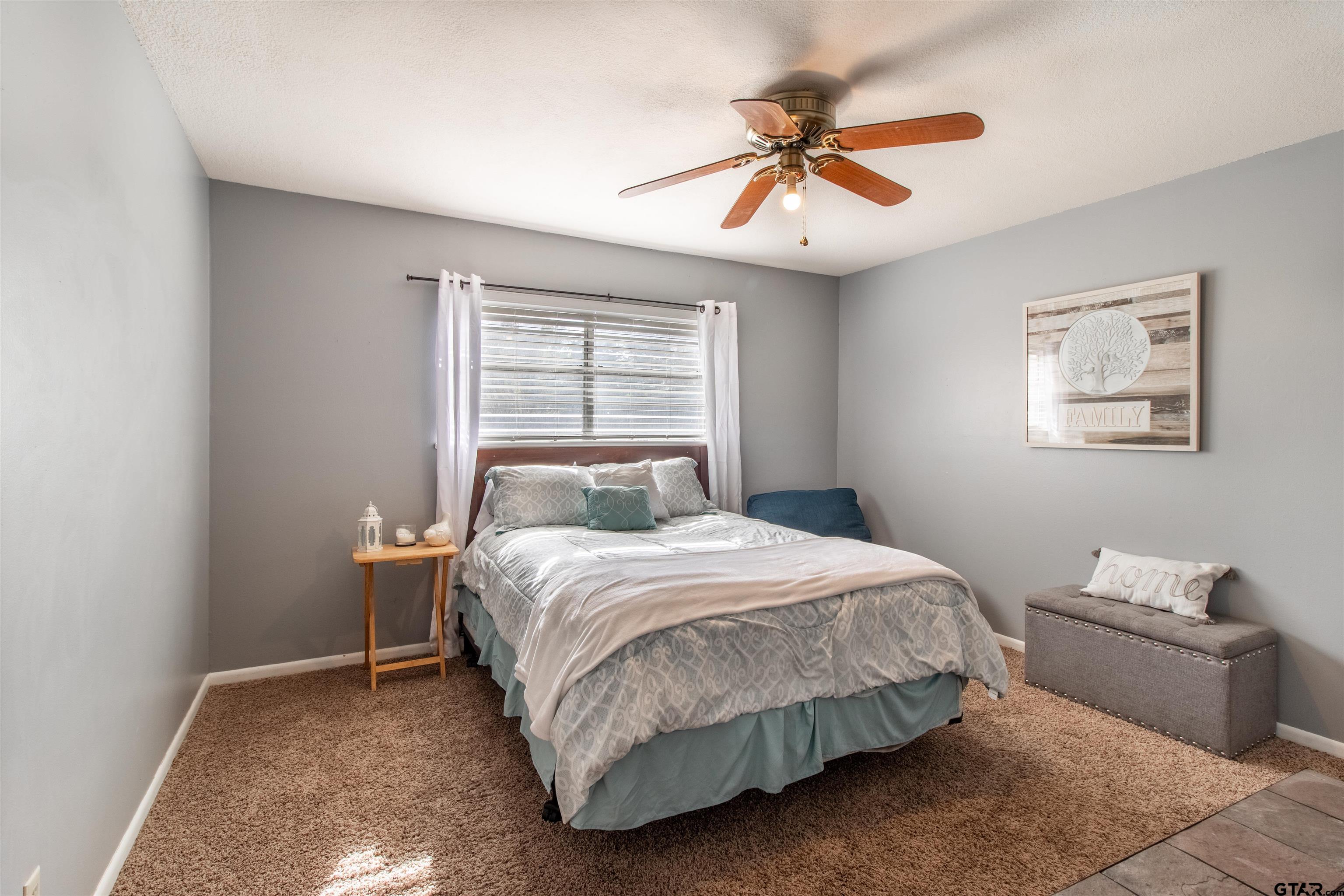 727 Oxford Drive Tyler, TX 75703 - Photo 21 of 33 a bedroom with a bed and a chandelier