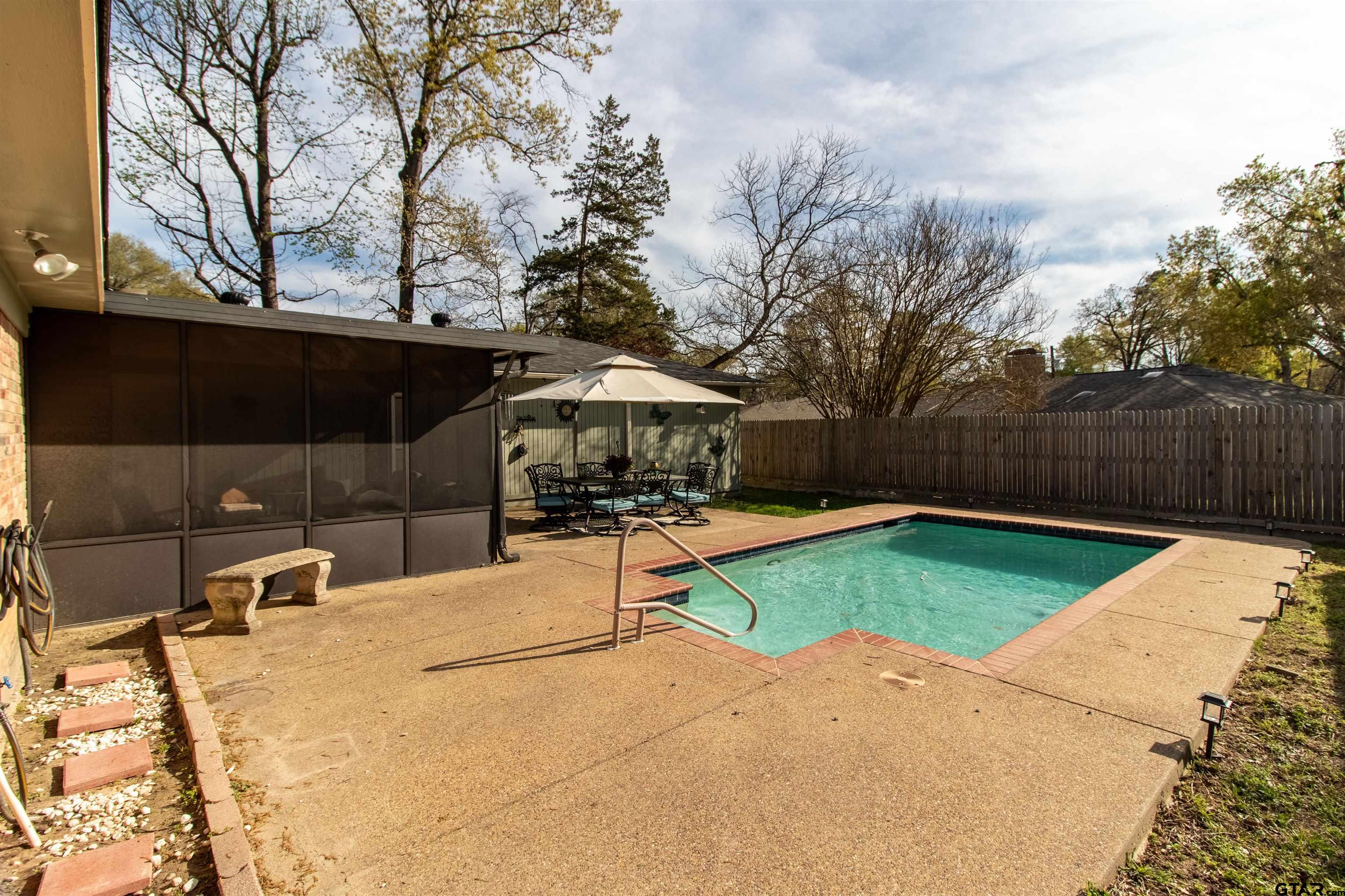 727 Oxford Drive Tyler, TX 75703 - Photo 28 of 33 a view of a patio with table and chairs under an umbrella with large trees