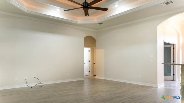 a view of a livingroom with wooden floor and a ceiling fan