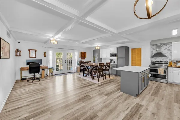 a living room with furniture and a dining table with kitchen view