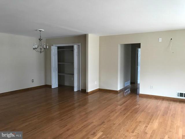 8149 Elizabeth Road Pasadena, MD 21122 - Photo 6 of 18 an empty room with wooden floor and closet